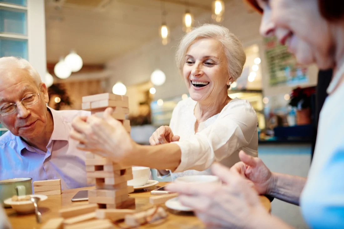 Des seniors jouent ensemble autour d'une table