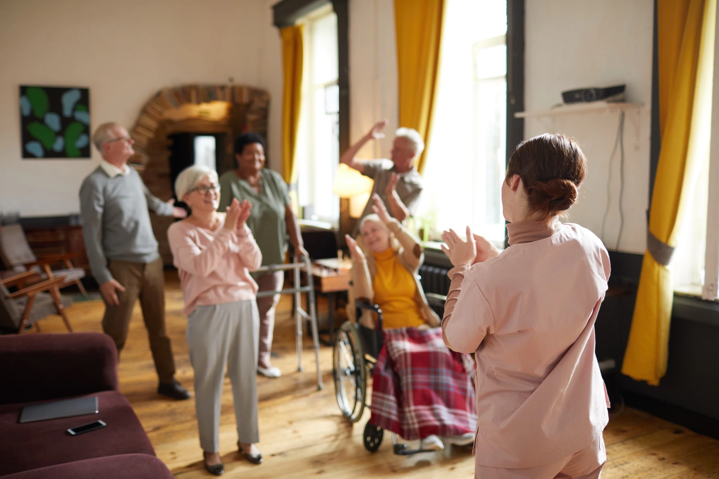 Groupe diversifié de résidents seniors souriant et dansant ensemble lors d'une animation organisée à l'EHPAD, ambiance joyeuse et vie sociale dynamique